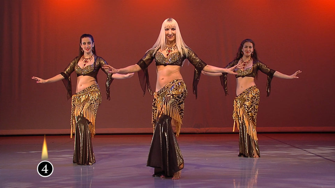 Three women in ornate gold and brown belly dance costumes perform on stage under warm, reddish lights in "Sample Instant Video" by Neon, with the number 4 and a flame hinting at a mesmerizing dance performance.
